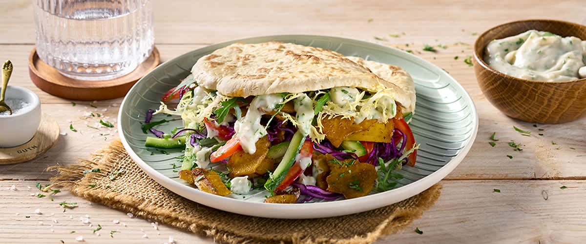 Punjeni somun s veganskim sastojcima na zelenom tanjuru