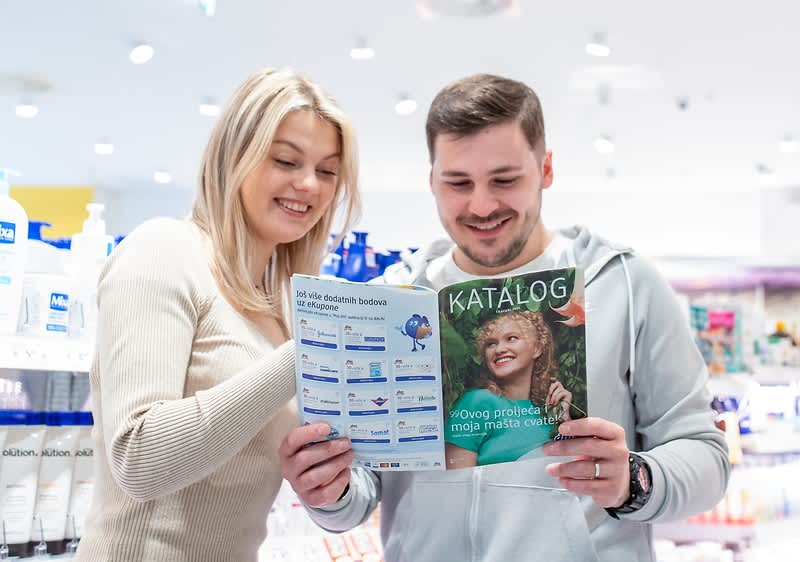 Dvije žene kupuju u dm-u i pročavaju dm katalog.