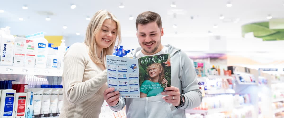Dvije žene kupuju u dm-u i pročavaju dm katalog.