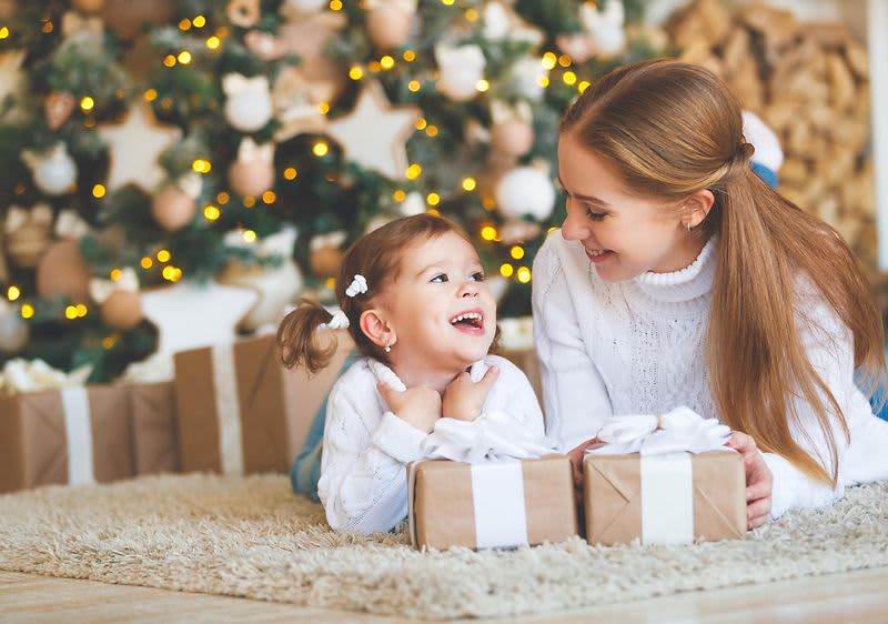 Mama i dijete ispod božićnog drvca