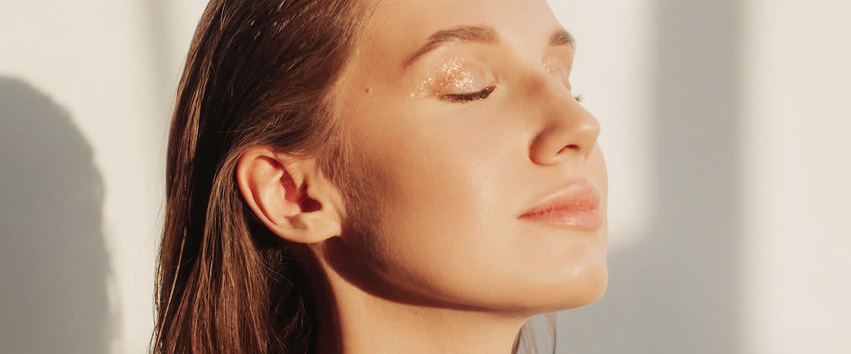 Djevojka, čije lice obasjavaju zrake sunca