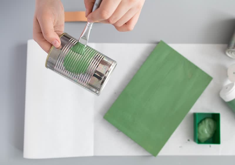 Prazne konzerve, zelena boja, kist