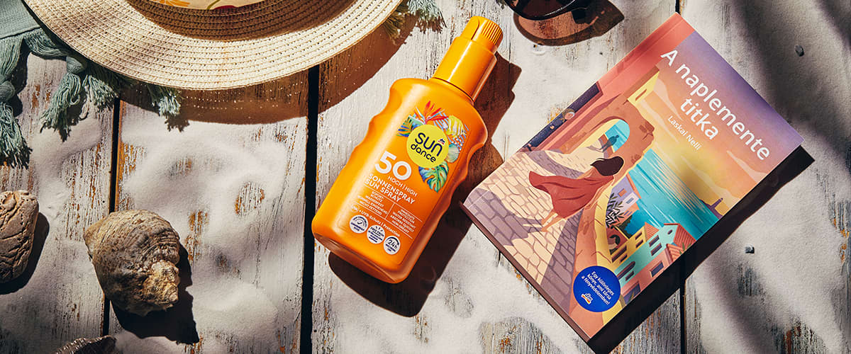 Napozókrém SPF50 a napernyő árnyékában kalap és Laskai Nelli: A naplemente titka című könyve