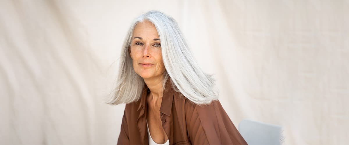 Hosszú ősz hajú nő mosolyog