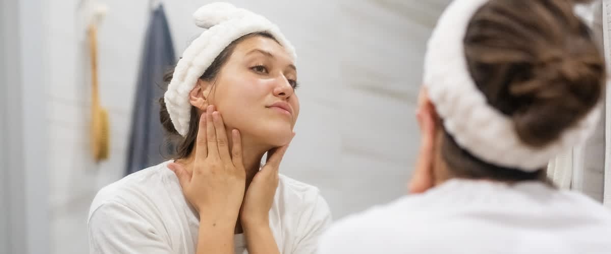 Frau cremt sich das Gesicht ein