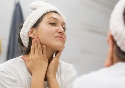 Frau cremt sich das Gesicht ein