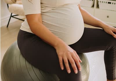 Terhes nő ül egy fitnesz labdán