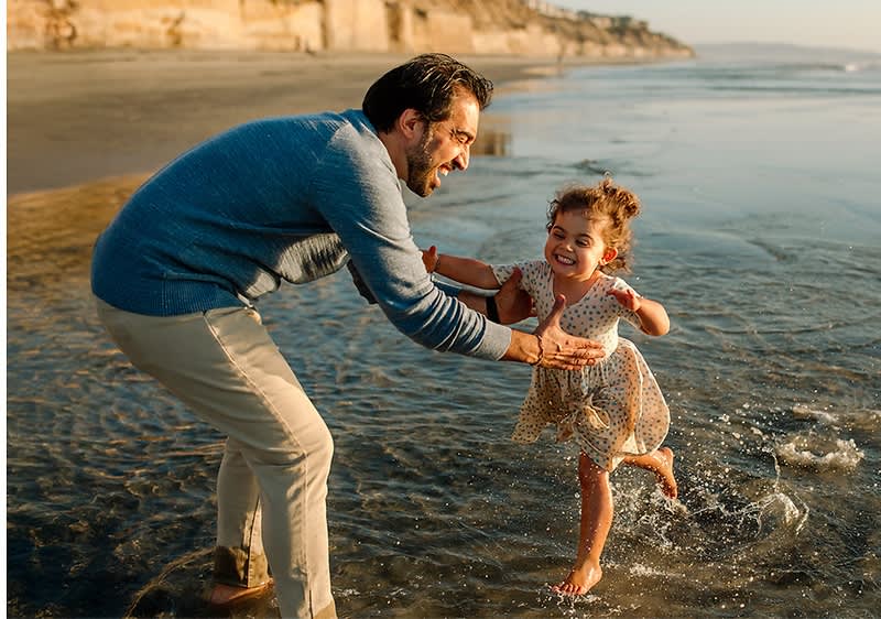 Strandspaziergang mit Kind und Erwachsenen im Wasser
