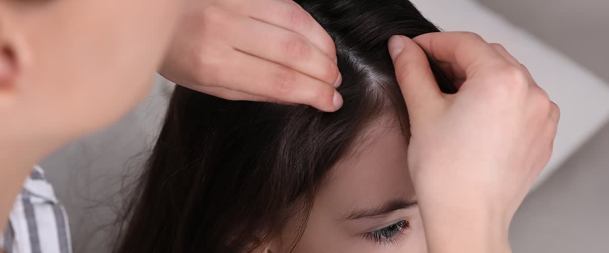 Anyuka átnézi a kislánya haját 