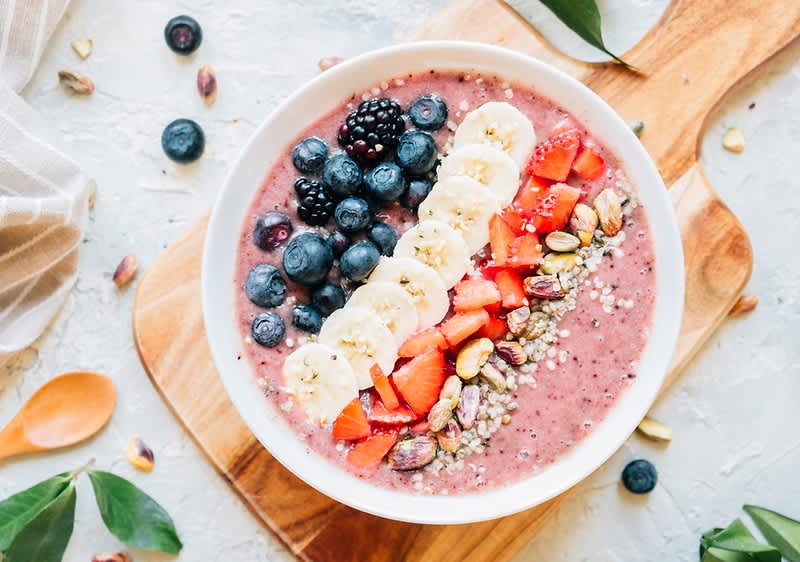 Gyümölcsös smoothie tál banánnal, bogyós gyümölcsökkel és magvakkal