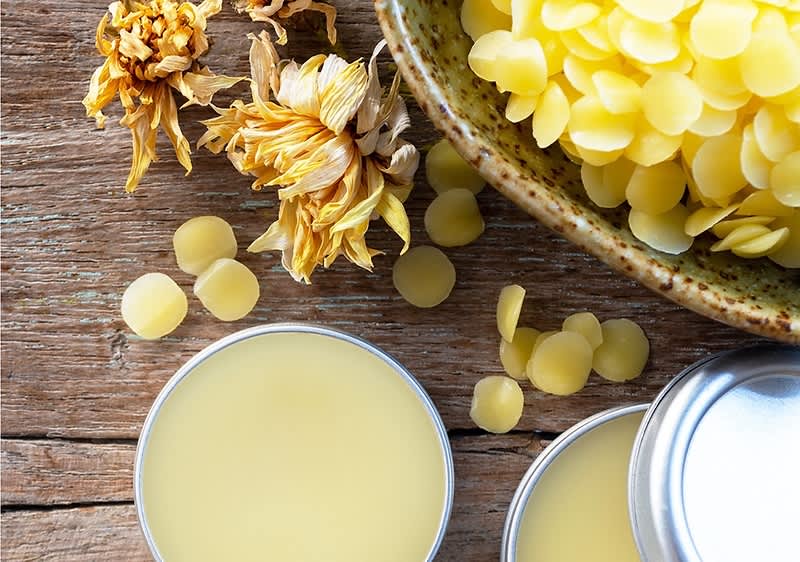 Méhviasz és ajakbalzsam egy tégelyben egy faasztalon