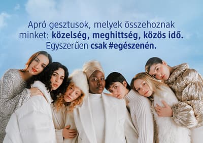 Csoportos ölelés téli ruhákban felhős háttér előtt