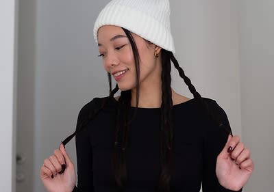 Fehér sapkában egy fonott hajú fekete nő