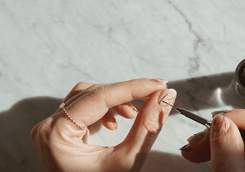 Egy nő kifesti a körmeit