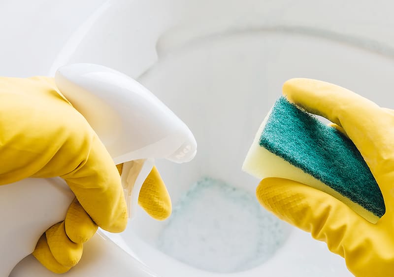 Tisztítás: Két sárga kesztyűs kéz, egyikben szivacs, másikban spray palack.