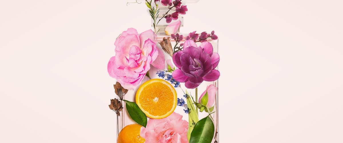 Parfüm üveg virágokkal és narancsszeletekkel