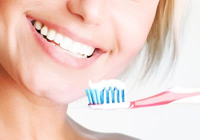 Frau putzt ihre Zähne mit einer Handzahnbürste