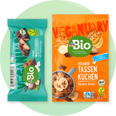 Prodotti vegani dmBio: barretta wafer e preparato di torta in tazza al banana bread su sfondo verde