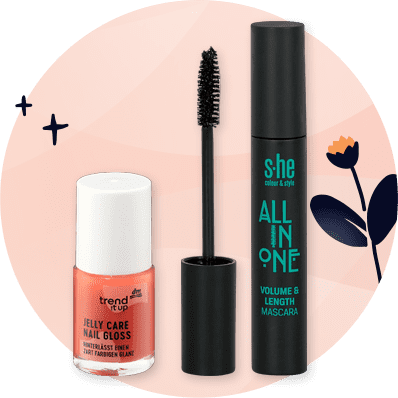 Cosmetici con smalto arancione e mascara su sfondo arancione con fiore e scintille