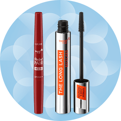 Trucco con matita labbra rossa e mascara nero a marchio trend it up su sfondo azzurro con elementi astratti bianchi