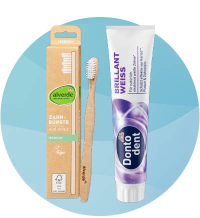 Spazzolino in legno alverde e dentifricio per denti bianchi Dontodent su sfondo azzurro sfumato