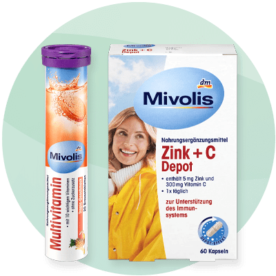 Integratori di vitamine Mivolis: compresse effervescenti multivitaminiche e scatola di integratore di zinco e vitamina C per supportare il sistema immunitario su sfondo verde sfumato-