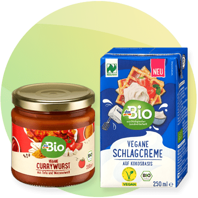 Prodotti vegani dmBio: currywurst e panna montata su sfondo verde sfumato