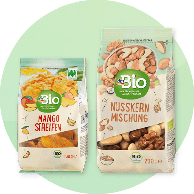 Confezioni di mango essiccato e mix di noci dmBio su sfondo verde sfumato