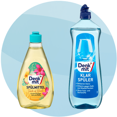 Due flaconi di detergente affiancati su sfondo azzurro: a sinistra un flacone giallo trasparente con tappo turchese etichetta “Denkmit Spülmittel Touch of Paradise” con fiori tropicali, a destra un flacone azzurro trasparente con tappo blu etichetta “Denkmit Klar Spüler”
