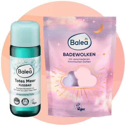Due prodotti Balea su sfondo rosa: a sinistra un flacone verde acqua etichettato Balea Totes Meer Fussbad (bagno per piedi, con testo tedesco e simboli vegano e dermatologicamente testato), a destra una confezione rosa-lilla Balea Badewolken con nuvola, luna e raggi dorati, scritta mit verschiedenen himmlischen Düften