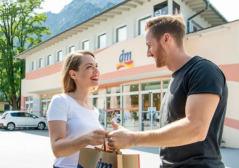 Un uomo e una donna con sfondo un negozio dm 