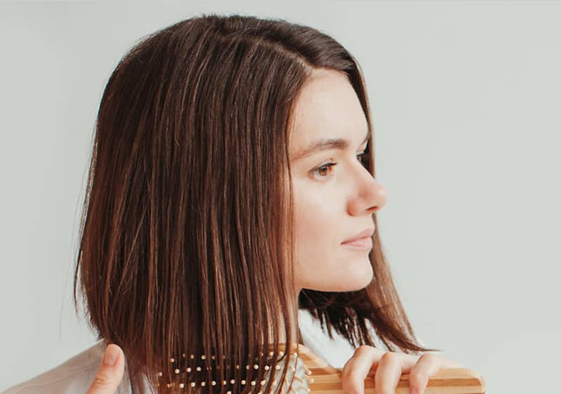 Frau, die sich die Haare kämmt
