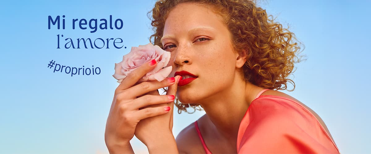 Una donna tiene una rosa rosa con lo smalto rosso. Testo: Mi regalo l'amore. #proprioio