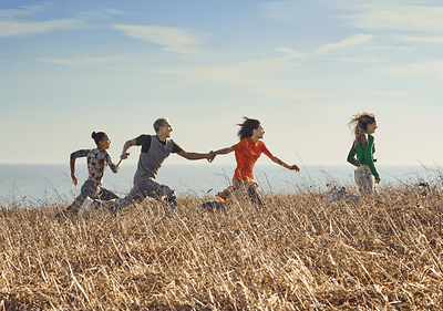 Persone che corrono in un campo vicino al mare
