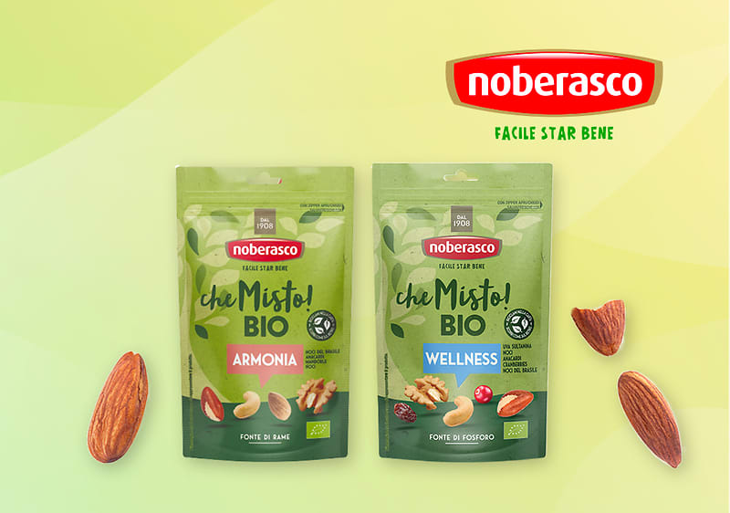 Snack Noberasco bio con mandorle e confezioni Armonia e Wellness su sfondo verde con mandorle