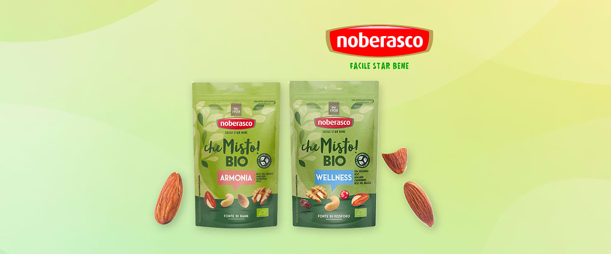 Snack Noberasco bio con mandorle e confezioni Armonia e Wellness su sfondo verde con mandorle