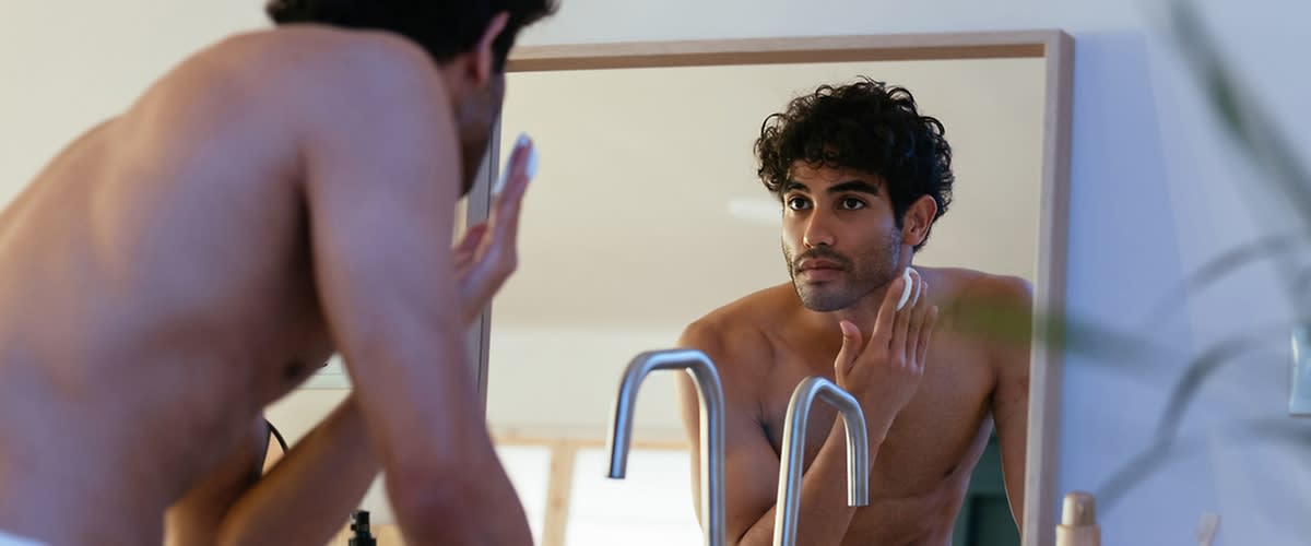 Uomo che si rade la barba davanti allo specchio