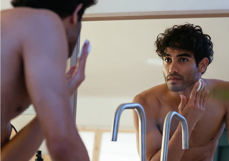 Uomo che si rade la barba davanti allo specchio