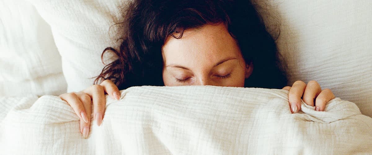 Donna raffreddata sotto alle coperte