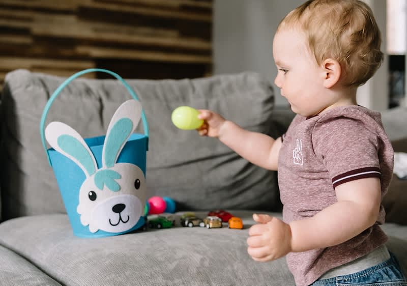 Bambino che gioca con il cestino di Pasqua