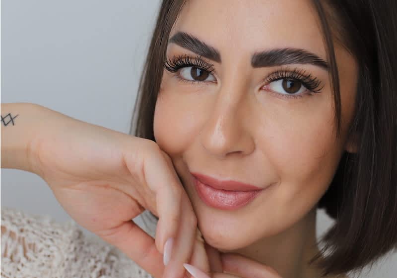 Ragazza truccata in posa con mano sul viso