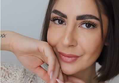 Ragazza truccata in posa con mano sul viso