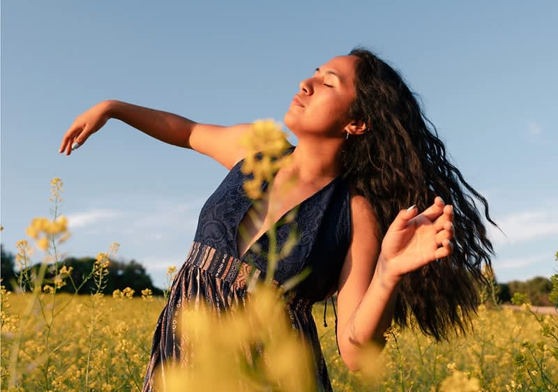 Donna che balla attraverso il prato fiorito