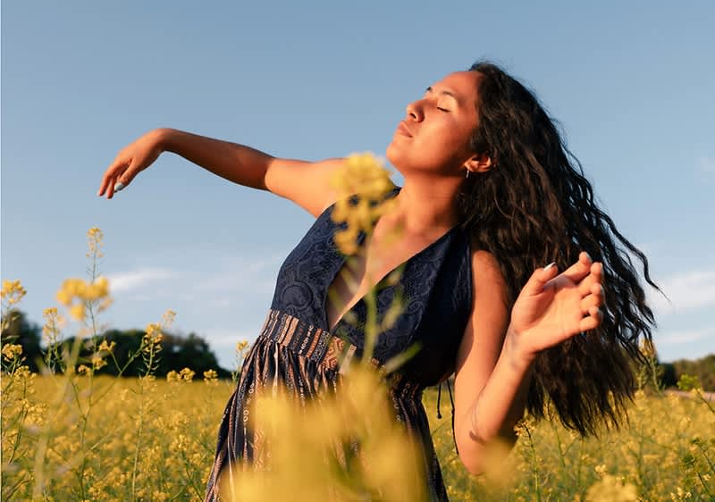 Donna che balla attraverso il prato fiorito