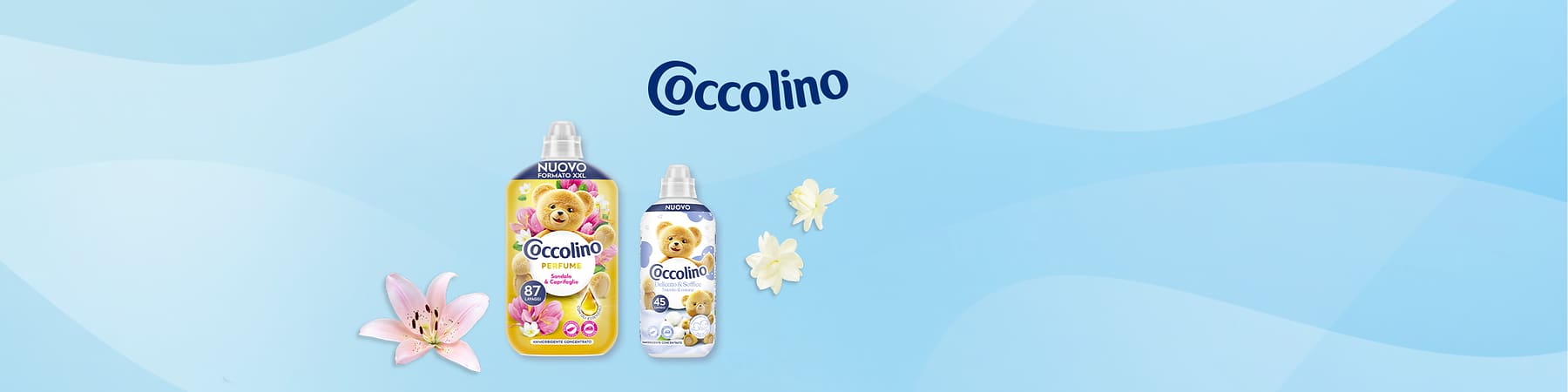 Bottiglie di ammorbidente Coccolino con orsetto su sfondo azzurro e fiori