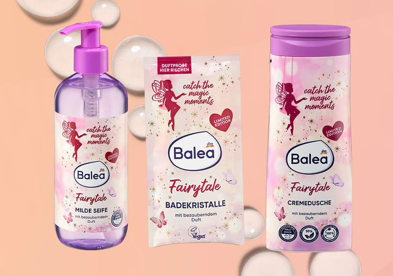 Prodotti Balea Fairytale con sapone, cristalli da bagno e crema doccia su sfondo sfumato con bolle di sapone