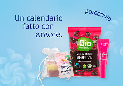 Calendario dell'avvento con prodotti cosmetici e snack bio a marchio dm con sfondo azzurro con fiocchi di neve