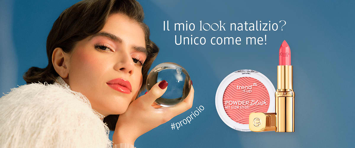Ragazza castana con look da festa tiene una sfera di vetro in mano. Sulla destra ci sono in primo piano due prodotti make-up: blush rosa trend it up e rossetto L'Oreal Paris.