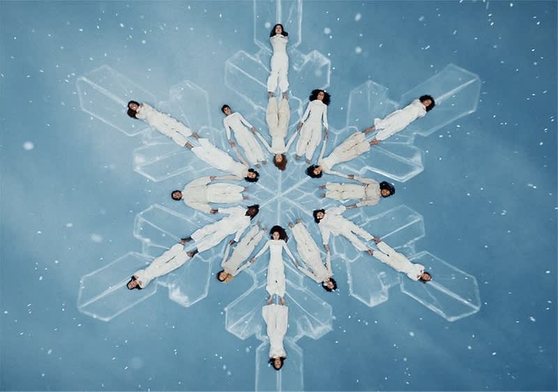 Fiocco di neve umano con persone in abiti bianchi su sfondo blu