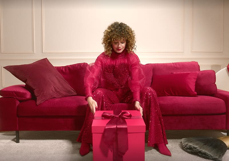 donna apre un pacco regalo per natale